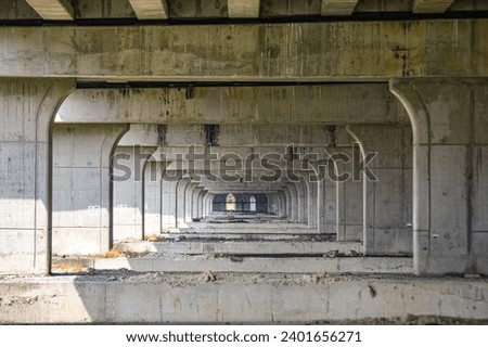 under toll road bridges or highways where there are many bridge pillars. perspective view.