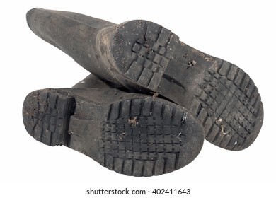 Under view of tread pattern on sole of dirty isolated pair of wellington boots