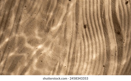 Under water texture light shadows on the beach sand. Close up