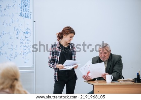 An underachieving student tries to solve an equation at the blackboard in college. The teacher sets difficult tasks for students at the institute