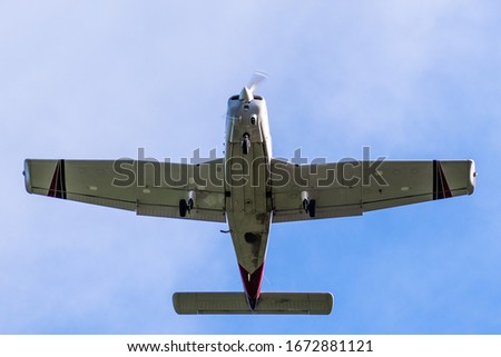 Undercarriage view of flying private airplane 