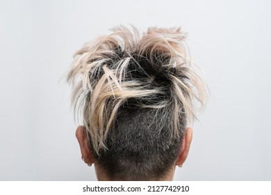 Undercut hairstyle with highlighted hair on a woman's head. Rear view. Defiant hairstyle.