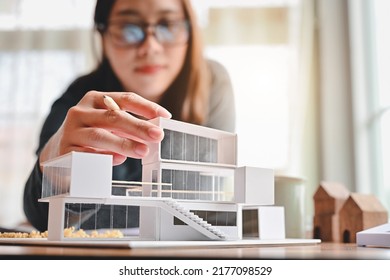 Undergraduate architecture students work on models of the modern box house. Holding the part of the model while thinking about concepts of building and construction. Focusing on her hand. - Shutterstock ID 2177098529