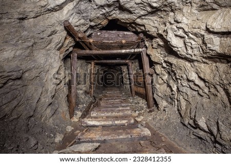Underground abandoned gold iron ore mine shaft tunnel gallery passage with wooden timbering