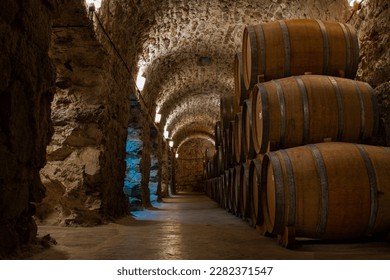 Underground brick and stone cellar with wooden barrels for storing malbec and tannat - Powered by Shutterstock