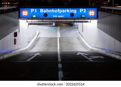 Underground Car Park Entrance With German Inscriptions In Luzern. Night View, Illuminated By Lights. Street Signs On The Ground. Nobody Inside 