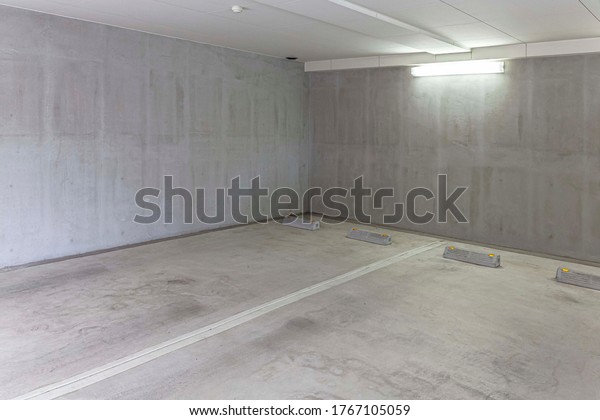 Underground car parking lot. Indoor\
parking area. Concrete basement floor parking\
garage