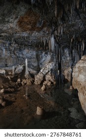 Underground cave forms a natural pool reflecting ancient stalactites and stalagmites