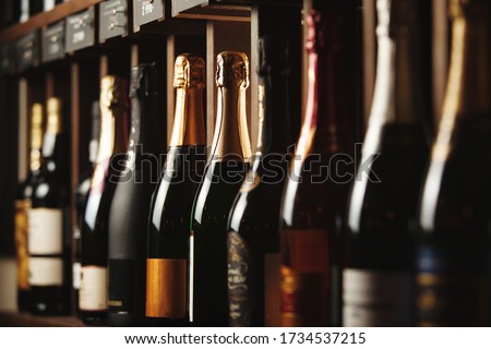 Underground cellar with elite sparkling wine on shelves, close up horizontal photo.
