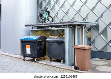 Underground garbage Bin Storage elevator lifting a parked bicycle - Shutterstock ID 2258106489