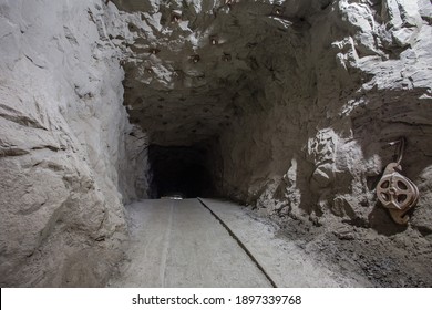 Underground gold mine shaft tunnel drift with rails and light - Shutterstock ID 1897339768