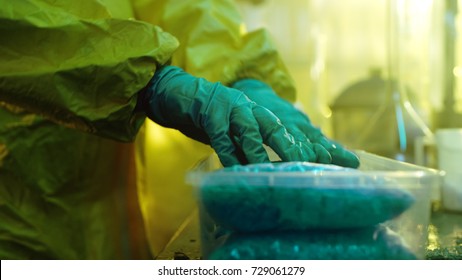 In the Underground Laboratory Clandestine Chemists in Protective Coveralls Package For Distribution Newly Cooked Batch of Drugs. They Illicitly Cook Drugs with Special Lab Equipment in the Laboratory.