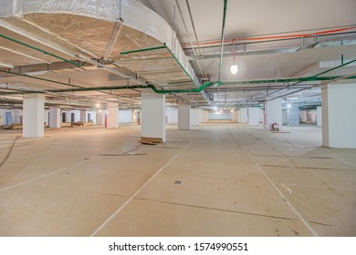 Underground Parking In Construction Phase. Empty Garage In Basement Of Office Building Under Construction. Parking Without Cars. Reinforced Concrete Monolithic Walls In Basement Of House Before Repair