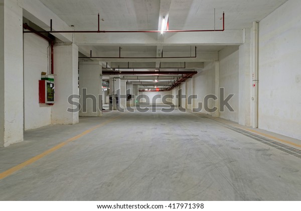 Underground parking lot. Basement\
parking. Car park spaces. Empty parking. Underground\
passage.