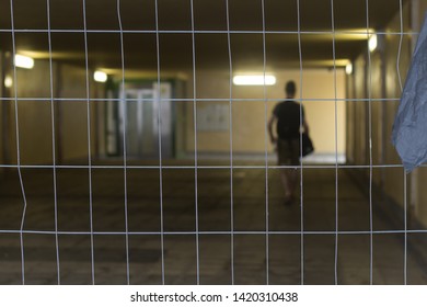 Underground passage for pedestrians with a blurred person walking. View through a fence. Gdansk Wrzeszcz, Poland
