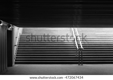 Underground passage walk. Exit to the city. Way out. Abstract black-and-white architecture photograph with back light.