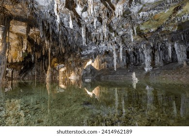 Underground pool with calm reflections with stalactites hanging from the ceiling inside the Lehman Caves in Great Basin National Park - Powered by Shutterstock