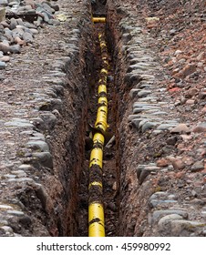 Underground Services Yellow Gas Polyethylene Pipe Being Sunk Into The Ground Under The Frost Line.