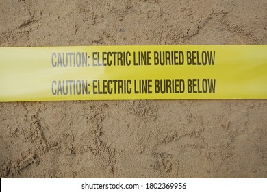 Underground warning tape placed on the sand to alert the underground power lines in the chemical plant construction project.