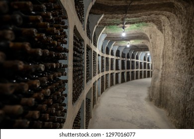 Underground Wine Cellar With Aging Wine Bottles In Racks