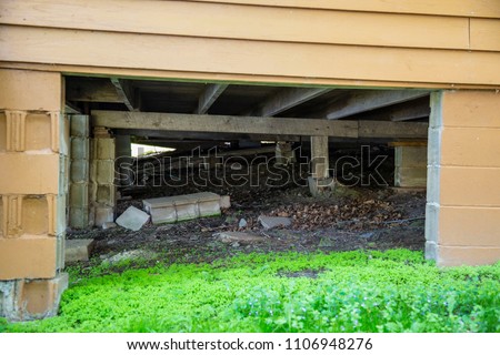 Underneath a house cabin structure foundation cinder block crawl space support system architecture wood construction carpenter