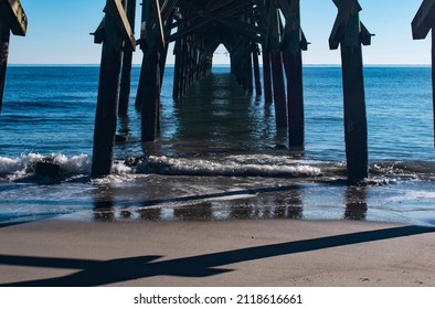 underneath a pier with waves 