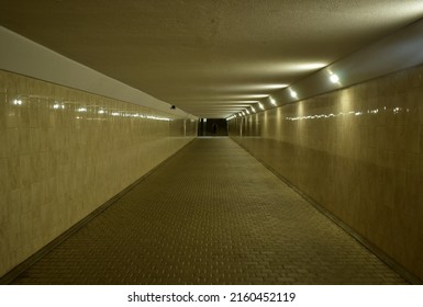 Underpass with electric lighting and reflection of light from walls with ceramic tiles