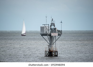 A Undersea Power Cable Pier In The Charleston Harbor With A Sailboat In The Background