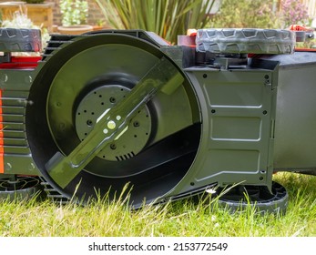 underside of a cordless lithium ion battery powered lawn mower exposing the cutting rotary blade
