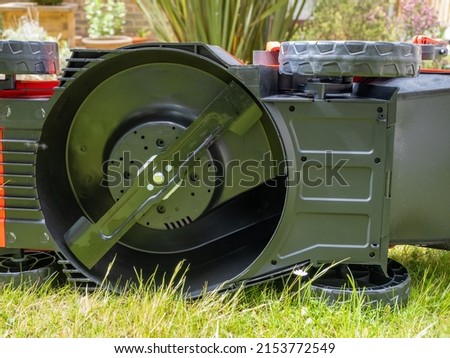 underside of a cordless lithium ion battery powered lawn mower exposing the cutting rotary blade