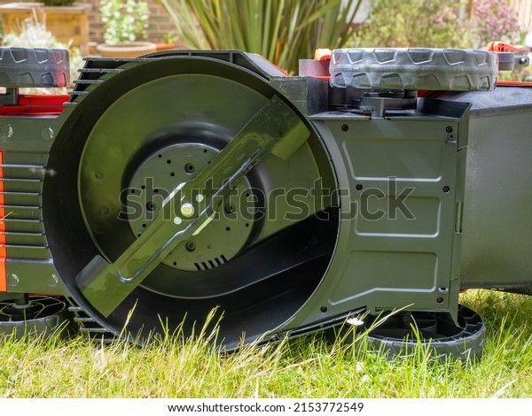 underside of a cordless lithium ion\
battery powered lawn mower exposing the cutting rotary\
blade