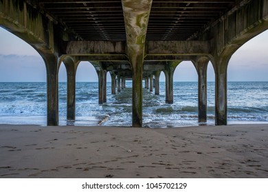 The underside of a pier by the ocean