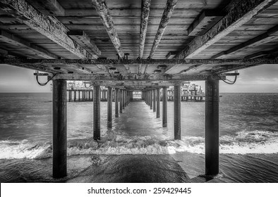 The underside of a pier with rest area on the end of it, black and white - Powered by Shutterstock