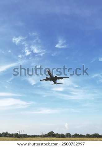 Underside view of airplane taking off above a field. Baden-Baden airport, Germany
