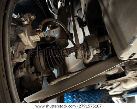 Underside view of a front-wheel-drive vehicle showing well-maintained suspension and steering components, including stabilizer links, tie rods, and rack steering in excellent condition.