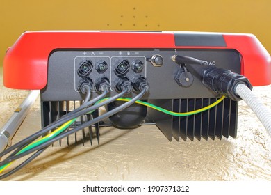 Underside view of a solar inverter showing cable connections