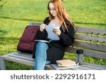 Understanding Student Loan Repayment Options. Pros and Cons of Federal vs Private Student Loans. Young student girl in glasses and with laptop and books reading letter outdoors
