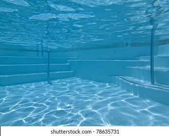 Underwater approach to stairs and seating in a clean suburban pool.