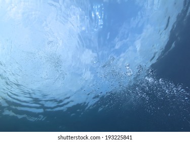 Underwater bubbles which raise from the depth of blue sea.