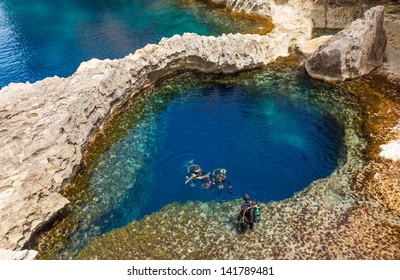 underwater cave in the form of heart and divers at Azure Window in Gozo, Malta