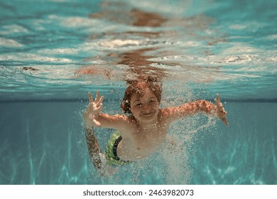 Underwater child in the swimming pool. Cute kid boy swimming in pool under water. - Powered by Shutterstock