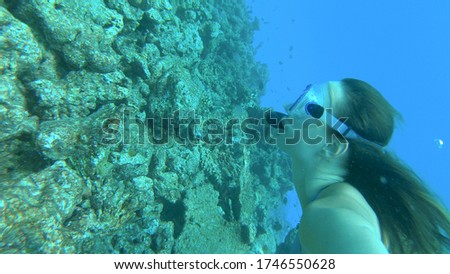 UNDERWATER, CLOSE UP: Young woman on a fun snorkeling trip in the picturesque Maldives dives along a bleached coral reef. Caucasian tourist girl explores the remnants of a once vibrant coral reef.