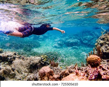 Underwater Image Of 7 Year Old Boy Snorkeling Through Coral Reef Near Ambergris Caye, Belize