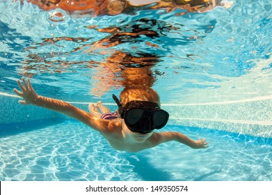 Underwater Little Kid In Swimming Pool With Black Mask.