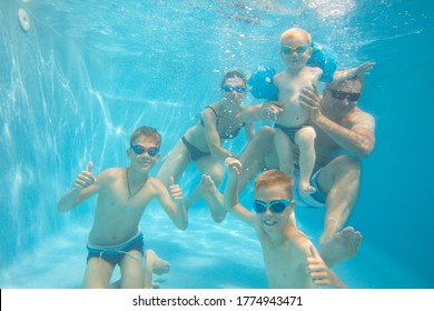 Underwater Photo Of Big  Young Family With Kids In Swimming  Pool