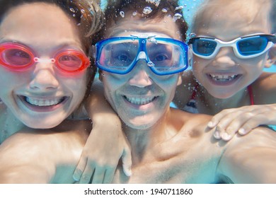 Underwater Photo Of  Little Boy With His Family  Swimming  In Pool