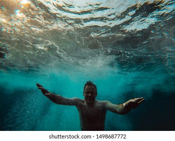 Underwater Photo Of Man Emerging From The Blue Water