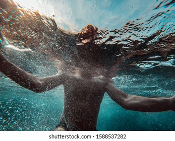 Underwater Photo Of Man Emerging From The Blue Water