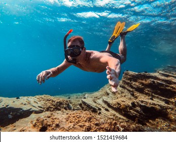 Underwater Photo Of Men Snorkeling In The Sea By The Tropical Reef