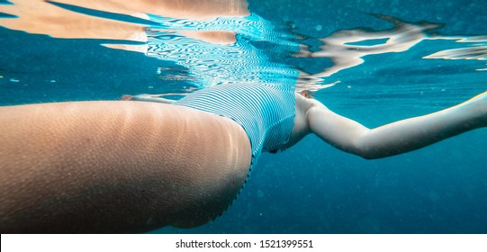 Underwater Photo Of Woman Floating In The Cold Water With Goosebumps On Her Skin